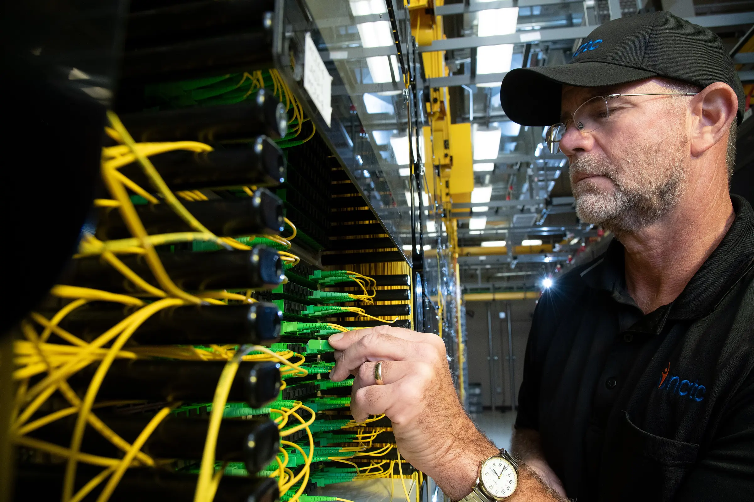 Yellow fibre-optic patch cables in a network cabinet
